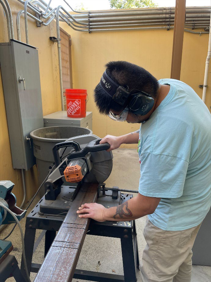 Team member cutting steel during fabrication